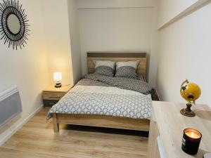 a bedroom with a bed and a table and a mirror at La Cave aux Lumières in Renaison