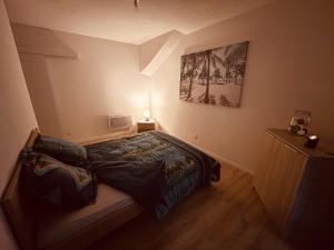 a bedroom with a bed and a picture on the wall at La Cave aux Lumières - Proche centre-ville - 2 chambres - Wifi in Renaison