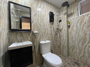 a bathroom with a toilet and a sink and a mirror at Langkawi Simfoni Beliza Apartment with Sky Pool by Zervin in Kuah +62 photos