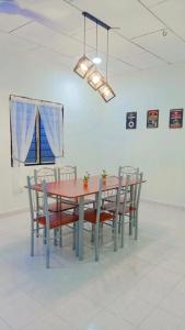 mesa de comedor con sillas y mesa roja en Casa Homestay D Sekinchan en Sekinchan