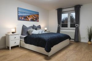 ein Schlafzimmer mit einem Bett und einem Fenster in der Unterkunft Ferienwohnung Landblick in Emmelsbüll-Horsbüll