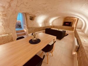 a dining room with a wooden table and a fireplace at La Cave aux Lumières in Renaison