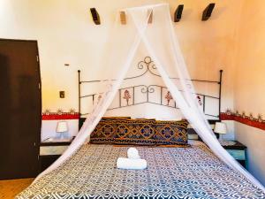 a bedroom with a canopy bed with a white mattress at Hacienda Antigua Villa, 50m from sandy Beach in El Cuyo