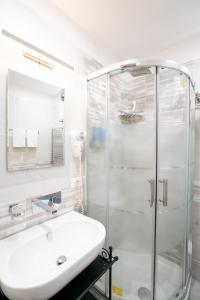 un bagno bianco con lavandino e doccia di Archi di Roma Guest House a Roma Altre 37 foto