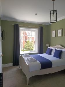sypialnia z dużym łóżkiem z niebieskimi i zielonymi ścianami w obiekcie North Ings w mieście Robin Hood's Bay