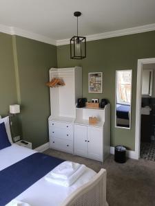 a bedroom with a bed and a cabinet and a mirror at North Ings in Robin Hood's Bay
