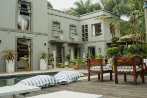 een huis met een patio met stoelen en een zwembad bij The Villa Salt Rock in Ballito