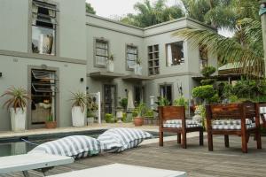 Casa con patio con sillas y piscina en The Villa Salt Rock, en Ballito