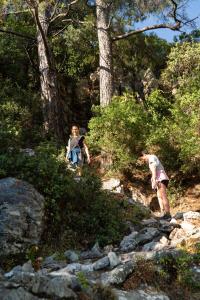 two people walking on a rocky trail in the woods at The Diplomat Hotel in Turunc