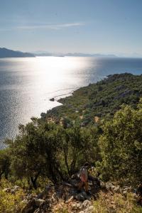 a person walking on a hill near the water at The Diplomat Hotel in Turunç