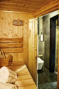 drewniana łazienka z toaletą i umywalką w obiekcie Apartament LOFTSPA w mieście Ustrzyki Dolne