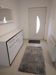 uma cozinha branca com uma porta e um tapete em Apartmani Đerek em Posusje