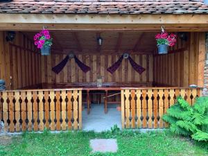 a wooden fence with a table and potted plants at Casa Mari in Cîrţişoara