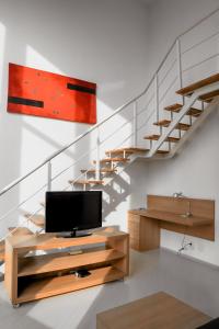 a living room with a tv and a staircase at Duplex Suite NYC Berrini 511 in Sao Paulo