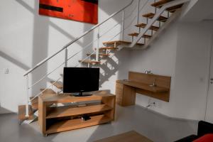 a living room with a tv and a staircase at Duplex Suite NYC Berrini 511 in Sao Paulo