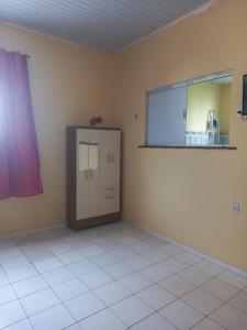 an empty room with a cabinet and a window at Apto em São Bráz in Belém