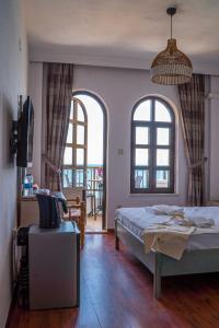 1 dormitorio con 1 cama y 2 ventanas grandes en The Diplomat Hotel, en Turunç