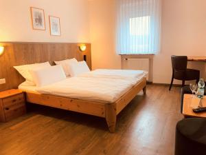 ein Schlafzimmer mit einem großen Bett in einem Zimmer in der Unterkunft Hotel Orthwein -kostenfreie Parkplätze- in Cölbe