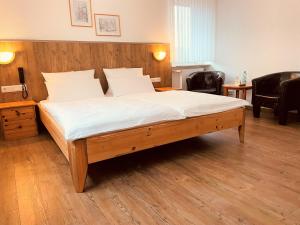 a bedroom with a large bed with white sheets at Hotel Orthwein -kostenfreie Parkplätze- in Cölbe