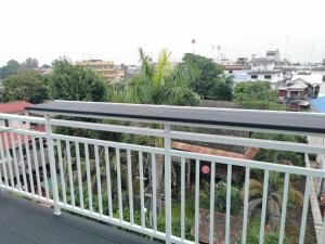 a balcony with white railings and a view of a city at สีดา​ โฮสเทล in Phetchaburi