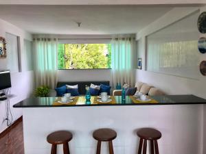 a kitchen with a counter and stools in a room at Apartamento Excelente in Arraial do Cabo