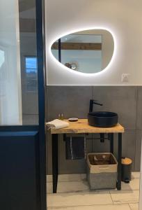 a bathroom with a sink and a mirror at La Glycine B&B in Sainte-Colombe