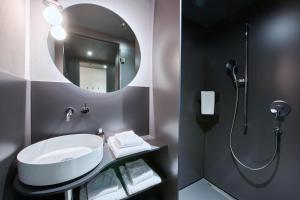 a bathroom with a sink and a shower at Apart Hotel Adelboden am Dorfplatz in Adelboden