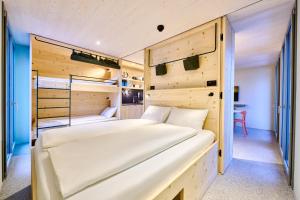 a bedroom with two beds in a room with wooden walls at Apart Hotel Adelboden am Dorfplatz in Adelboden
