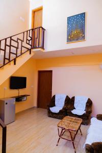 a living room with two couches and a staircase at Laughing Waters Fine Stay in Kuttālam