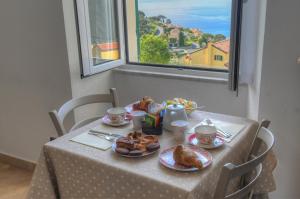 a table with breakfast food on it with a window at La Locanda di Cucco in Finale Ligure +12 photos