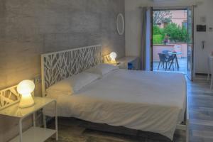 a bedroom with a large white bed and two tables at La Locanda di Cucco in Finale Ligure