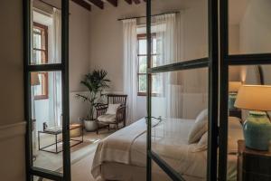 - une chambre avec un lit et une porte en verre dans l'établissement Cal Reiet Holistic Retreat, à Santanyí