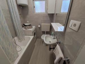 a bathroom with a sink and a toilet and a bath tub at APARTMENT IVANA in Brodarica
