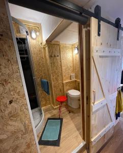 a small bathroom with a toilet and a red stool at Studio 7 in Hoogland