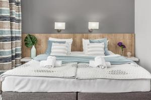 a bedroom with a large bed with towels on it at Willa 777 Krasickiego in Międzyzdroje