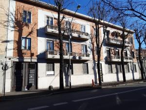 um edifício numa rua com árvores em frente em Casa vacanze - House Stop and Go em Busto Arsizio