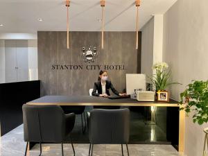 a woman wearing a mask sitting at a table in an office at Stanton City Hotel in Kota Kinabalu