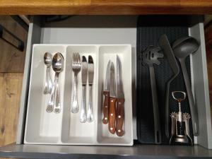 a white tray with silver utensils on a shelf at CozyStudio in Obninsk