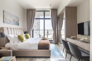 1 dormitorio con 1 cama y escritorio con TV en Frank Porter - Majestique Residence 2, en Dubái