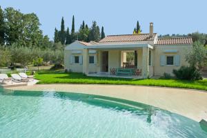 a villa with a swimming pool in front of a house at Villa Rodia in Áno Korakiána