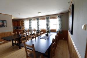 Fossanmoen في Forsand: غرفة طعام مع طاولة وكراسي طويلة