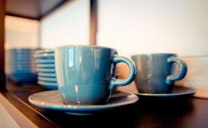 two blue cups and saucers sitting on a table at Apartament przy Rynku in Sanok