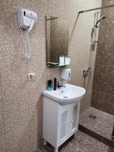a bathroom with a sink and a shower with a mirror at Капрі in Mukacheve