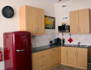 a kitchen with a red refrigerator and wooden cabinets at The Dutch Hills in Gulpen
