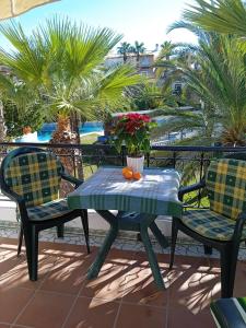 a table and chairs on a balcony with palm trees at Casa al mare Aldea in Torrevieja