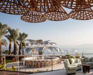 eine Terrasse mit Stühlen, einem Tisch und Meerblick in der Unterkunft Galei Kinneret Hotel in Tiberias