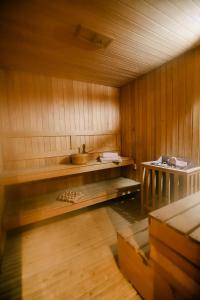 a sauna with a bench and a sink in it at Hotel Kocibelli POOL & SPA in Korçë