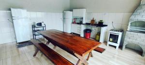 eine Küche mit einem Holztisch im Zimmer in der Unterkunft Casa Temporada Sol Nascente in Olímpia