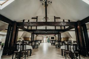 a dining room with tables and chairs and a chandelier at Complex Hanul Cavalerului in Onești