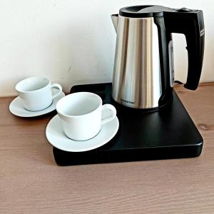 a coffee pot and two cups on a black tray at Kopeček - Penzion in Česká Lípa